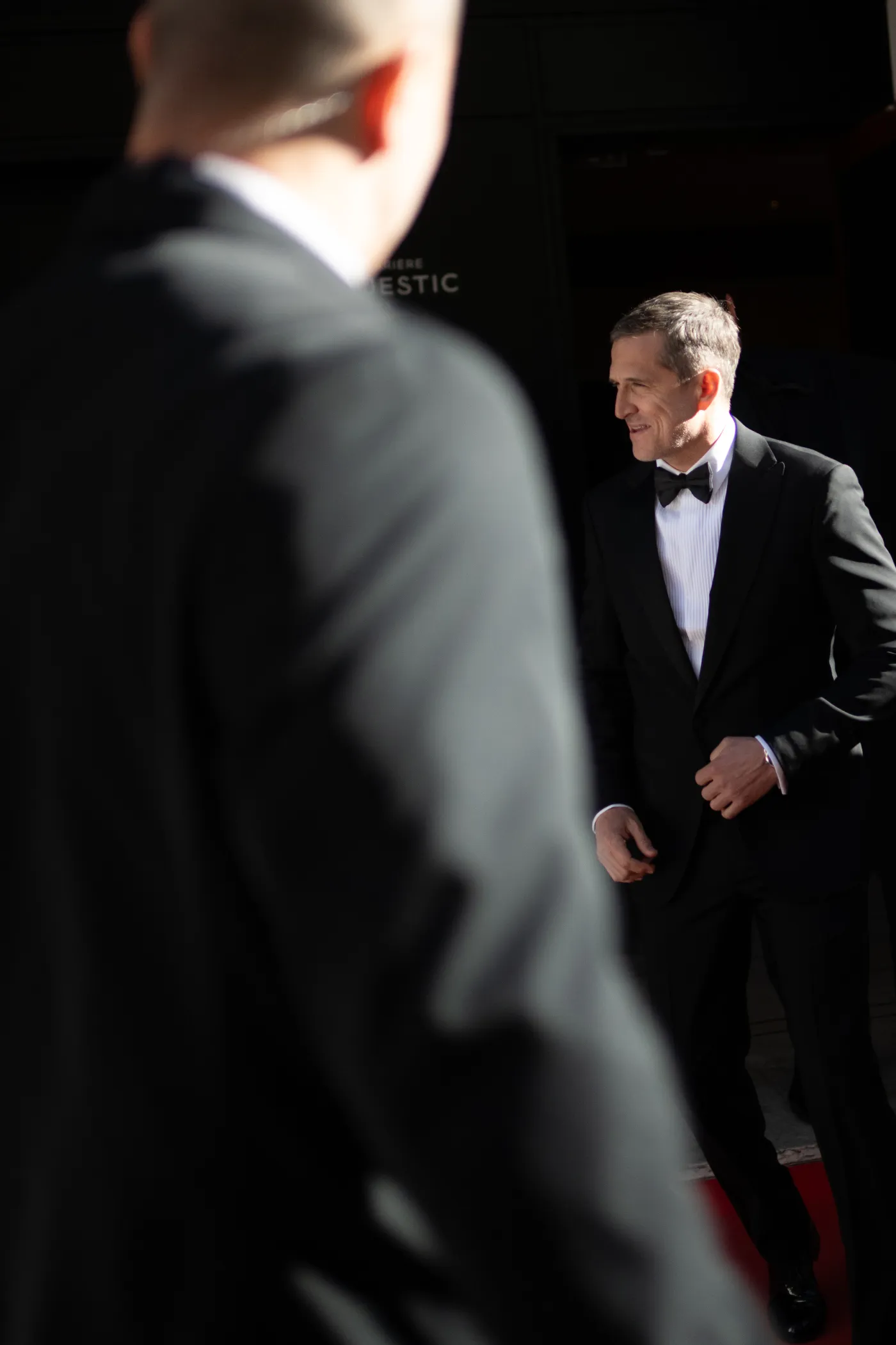 Personnalité en smoking à l'entrée d'un palace, tapis rouge