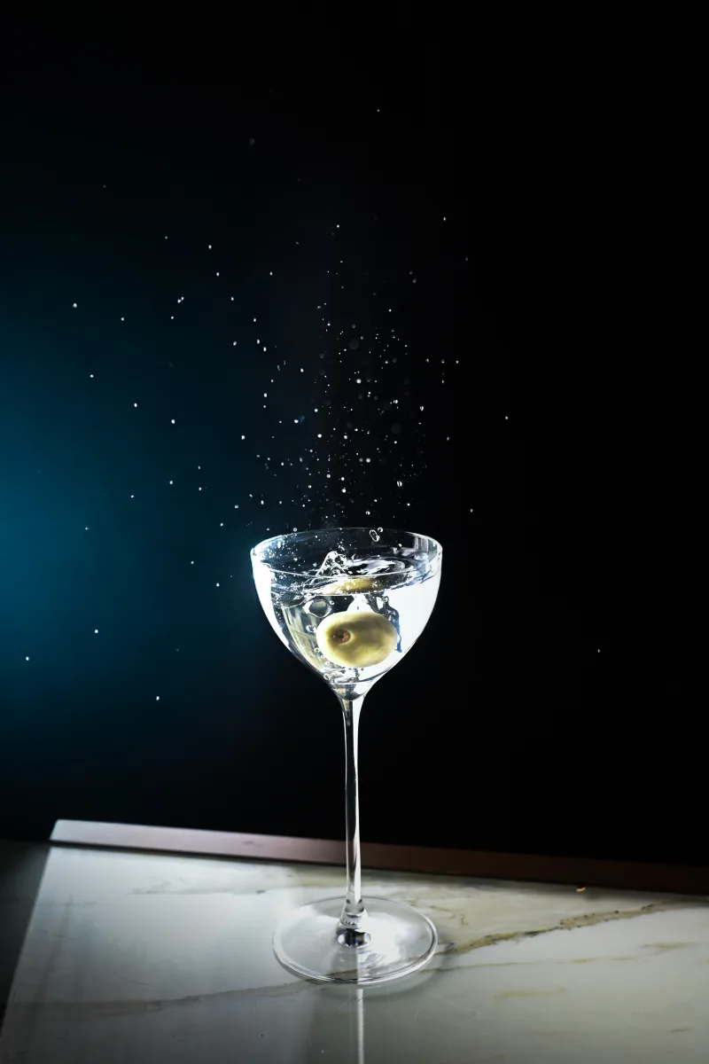 Cocktail martini, olive et éclaboussure figée sur fond nocturne