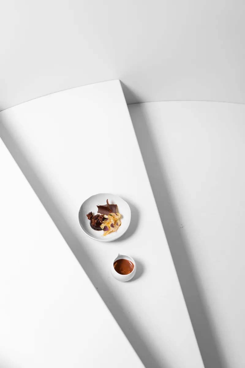 Dessert au chocolat et sauce caramel, composition graphique épurée sur fond blanc