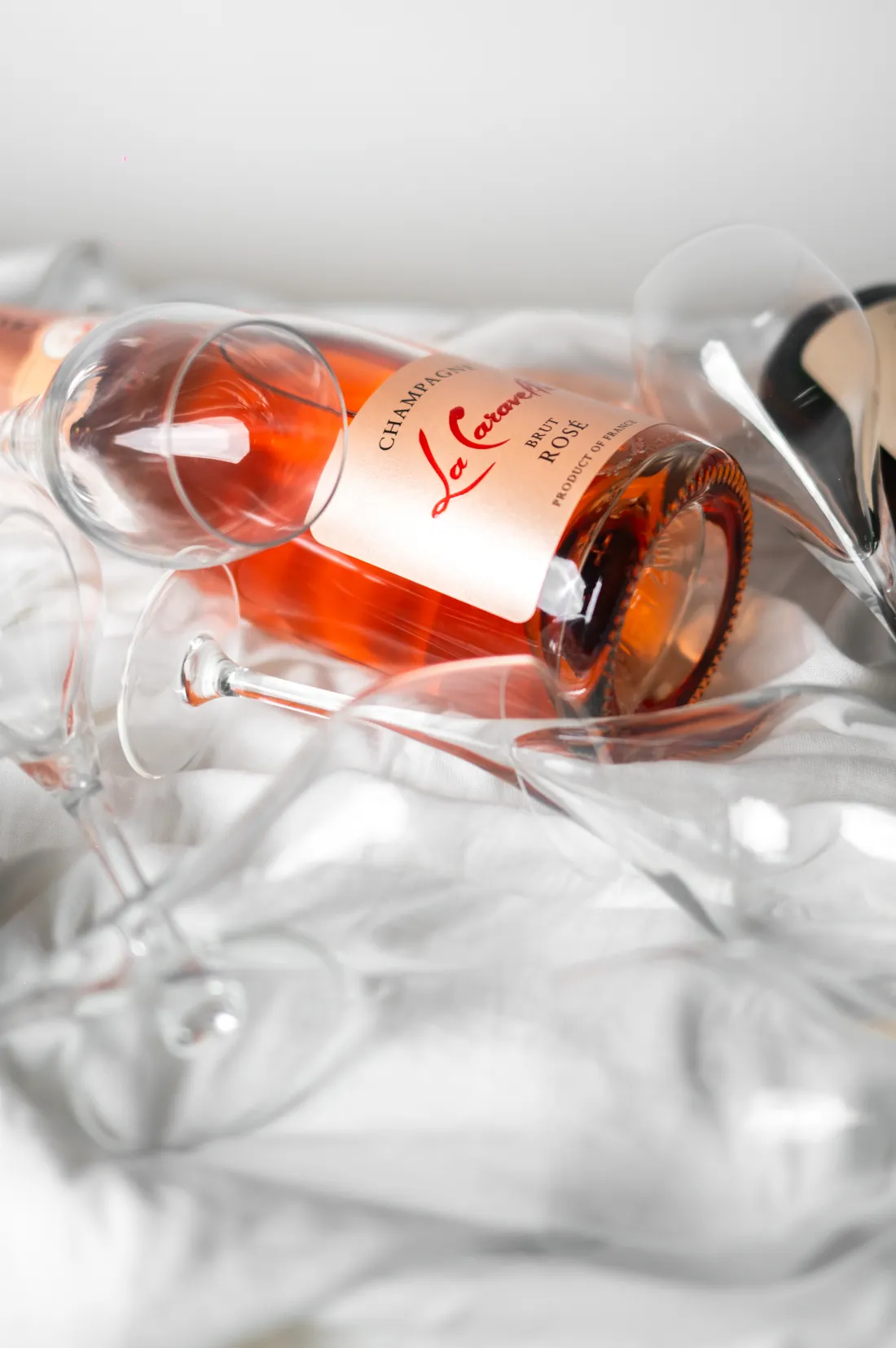 Champagne rosé et verres sur nappe claire